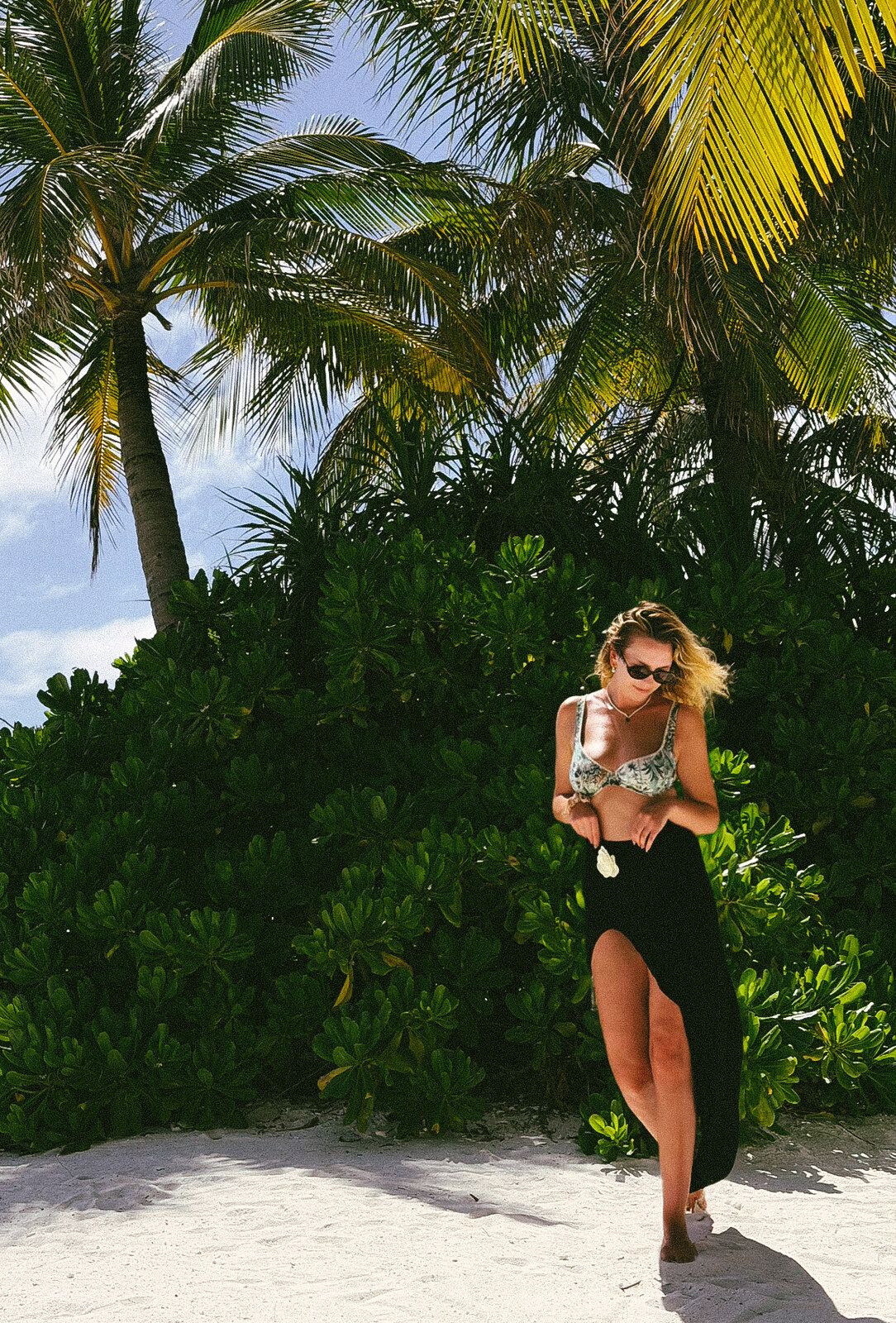 Anna walking along a tropical resort pathway